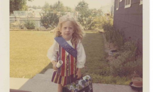 Ingrid Tischer on the day of her kindergarten graduation in Greece, New York, circa 1969. She is wearing a rainbow vest and skirt sown by her mom. Note the clutching of the diploma and school-bestowed book-bag, and anxious expression -- all indicate a future in literary fiction writing and nonprofit fundraising.